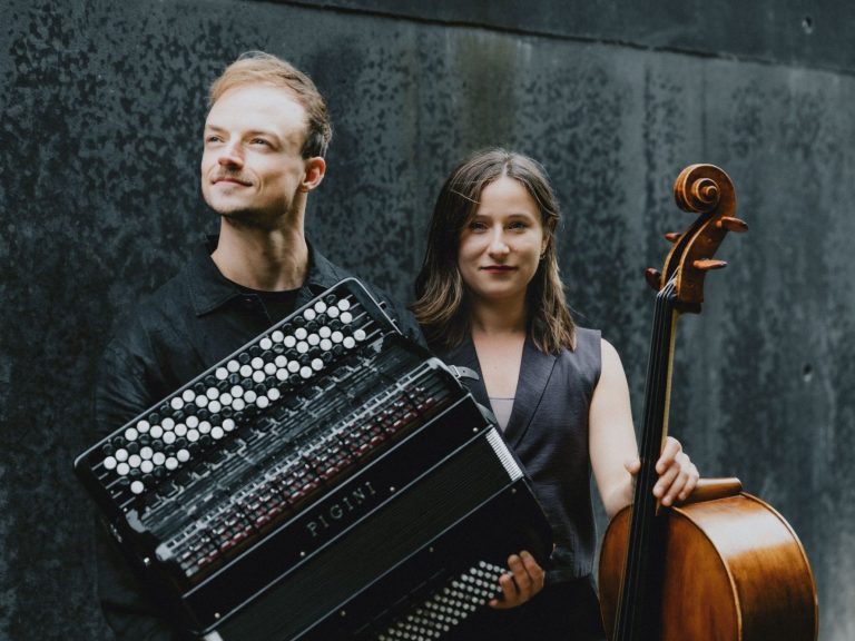 Duo Klangtreff Zwei Musiker in urbaner Umgebung; einer mit Akkordeon, die andere mit Violoncello.